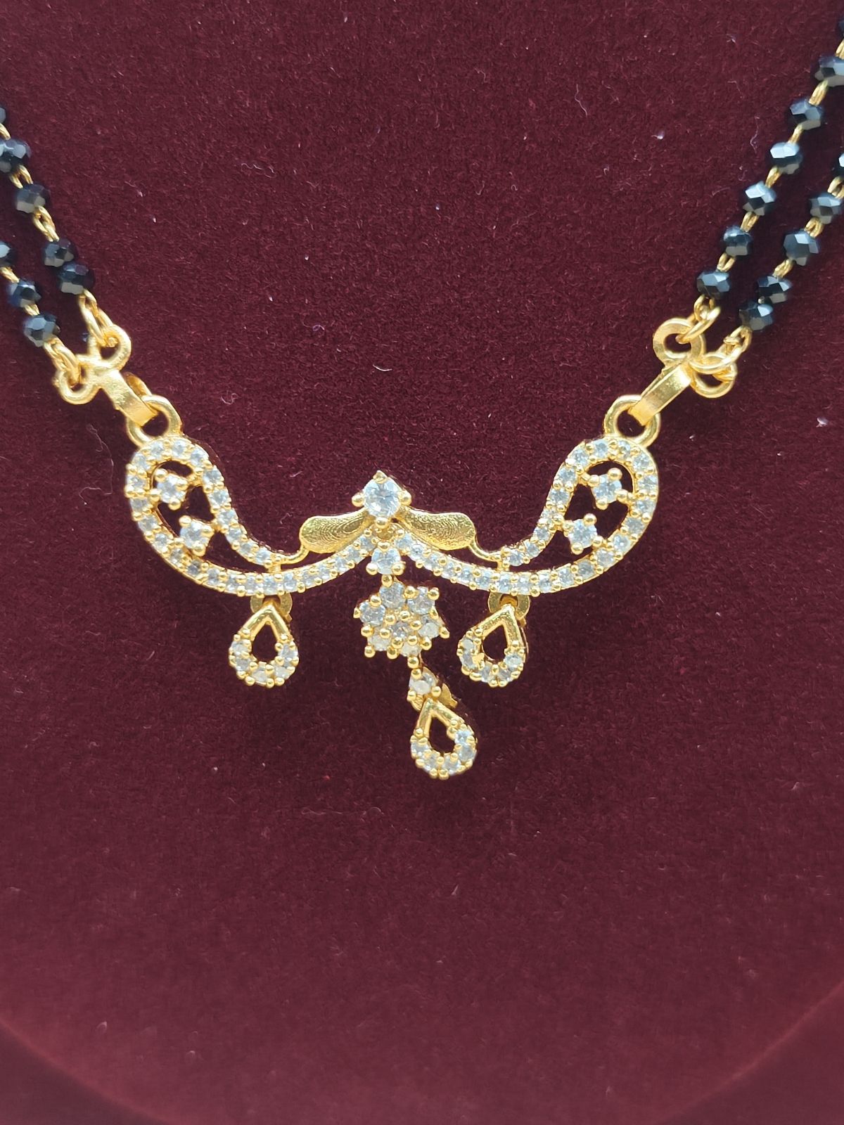 Double-line black beads mangalsutra chain with crystal-studded pendant with drop design.